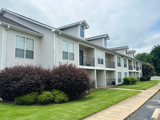 Charming apartment complex with modern design, lush landscaping, and inviting balconies.