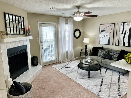 Inviting living room with a cozy fireplace, modern art, and a stylish seating area, perfect for relaxation and entertaining.