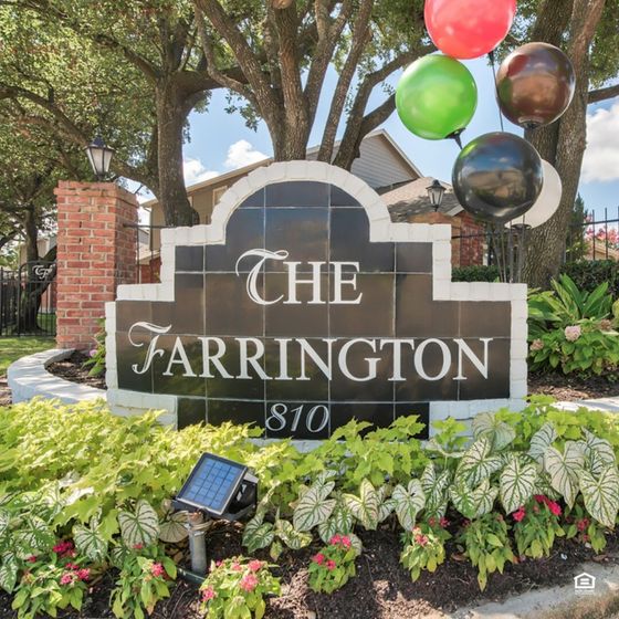 Inviting entrance sign of The Farrington with vibrant balloons and lush greenery, promising a warm welcome.