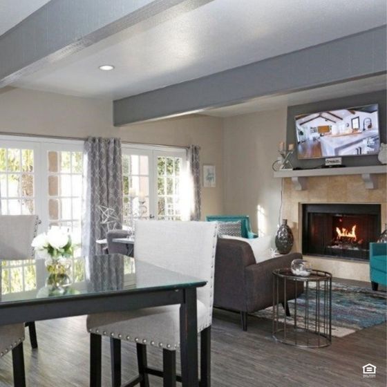 Elegant living area with stylish decor, featuring a cozy fireplace, modern furniture, and ample natural light from large windows.