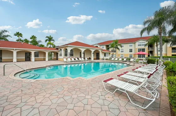 a photograph of a pool with buildings in the background