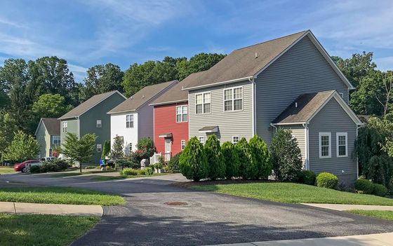 Charming suburban neighborhood with colorful houses, lush greenery, and a serene atmosphere.