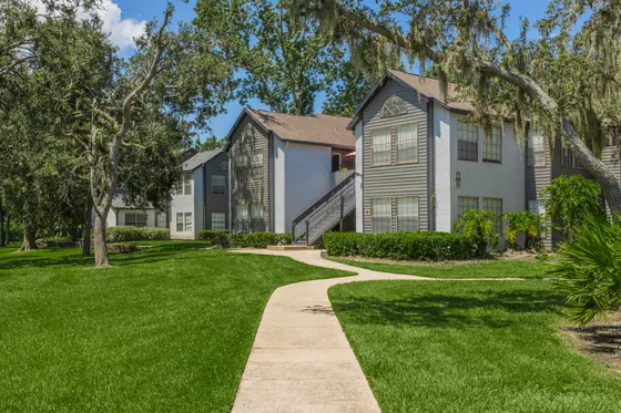 Charming suburban apartment complex surrounded by lush greenery and mature trees, offering a tranquil living environment.