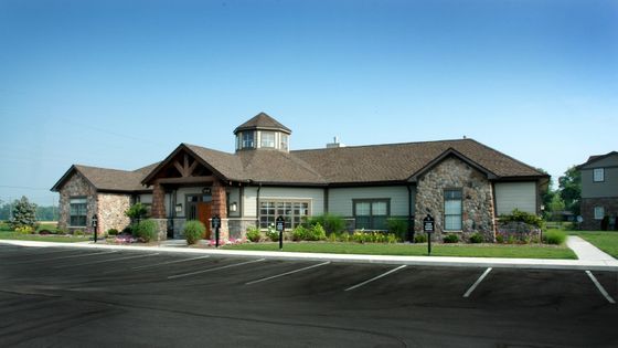 Charming stone-clad building with rustic design and manicured gardens in a serene setting.