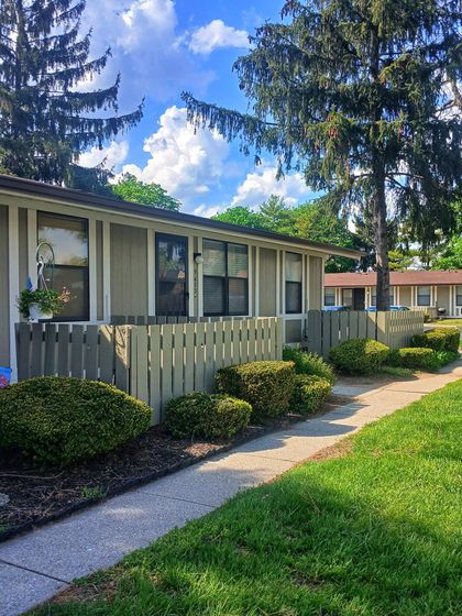 Charming single-story apartment with lush landscaping, cozy fenced patios, and serene natural surroundings.