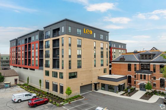 Modern urban apartment building with sleek design, featuring spacious balconies and vibrant exterior.