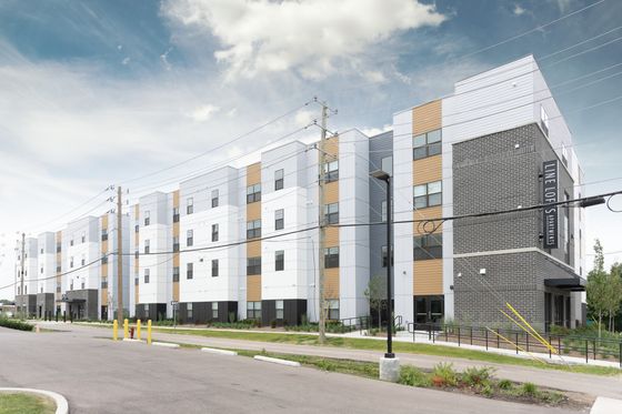 Modern and stylish apartment building with sleek architectural design, large windows, and contemporary facade on a sunny day.