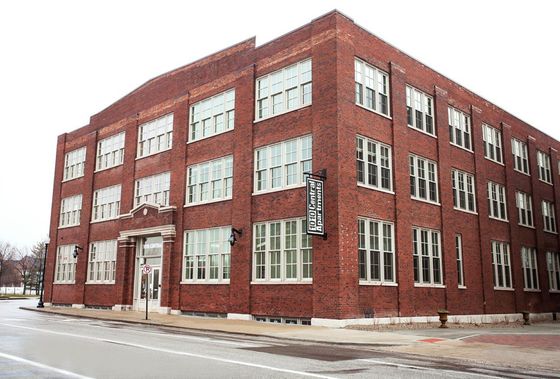Charming red brick apartment building with classic architecture and large windows, offering a welcoming urban living experience.
