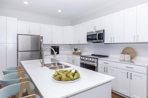 Modern kitchen design with sleek white cabinetry, stainless steel appliances, and a spacious island featuring elegant bar seating.