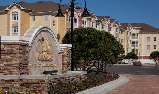 Charming multi-story apartments at Villa Grande with picturesque landscaping and elegant architecture.