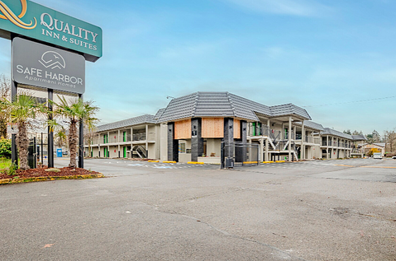 Inviting view of Safe Harbor Apartment Homes with Quality Inn & Suites signage, surrounded by lush greenery and a serene atmosphere.