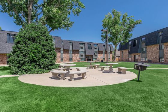Charming apartment complex showcasing manicured lawns, unique architecture, and inviting outdoor seating areas.