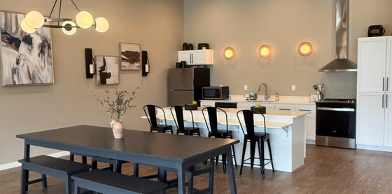 Modern open-concept kitchen and dining area with sleek bar seating, contemporary lighting, and stylish artwork on the walls.