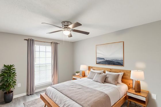 Bright and inviting bedroom with a cozy king-size bed, elegant decor, and abundant natural light from a large window.