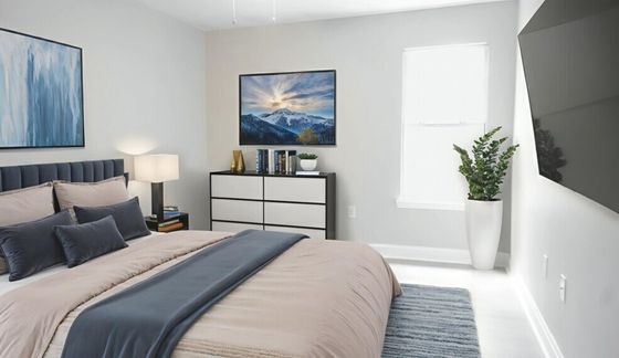 Elegant bedroom with modern decor, featuring a cozy bed with plush pillows, stylish artwork, and a sleek chest of drawers for storage.
