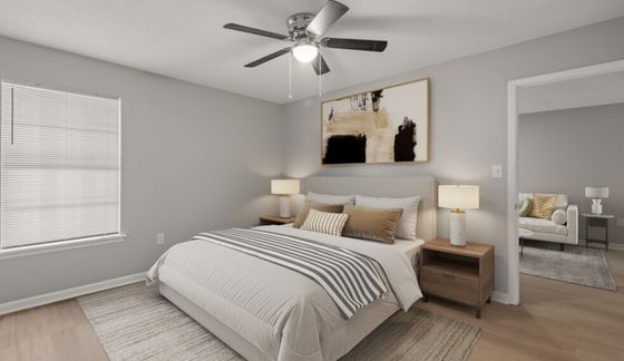 Chic bedroom with stylish decor, featuring a comfortable bed, modern ceiling fan, and natural light from a large window.