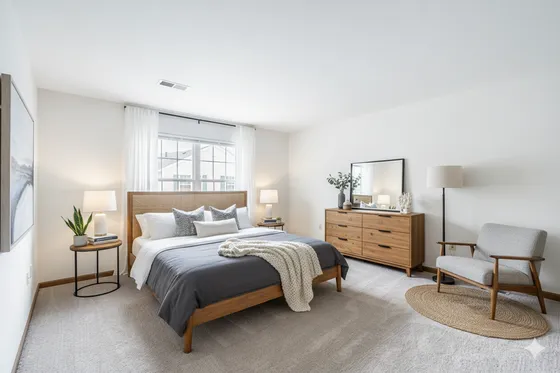 Bright and inviting bedroom with elegant decor, featuring a cozy bed, stylish wooden furniture, and natural light streaming through large windows.