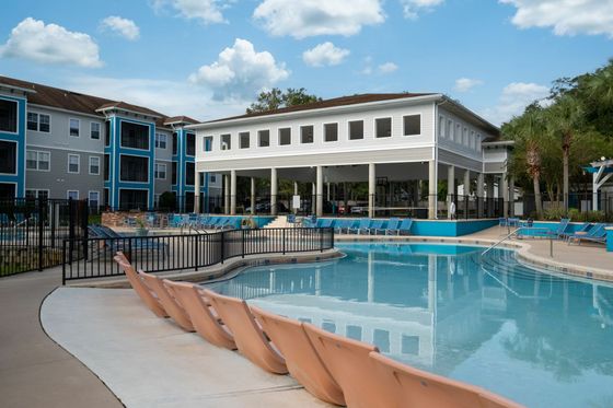 Pool with apartment and basketball court in background