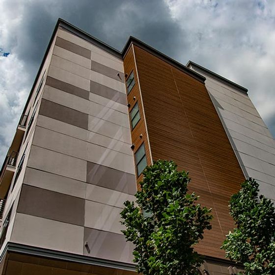 Elegant modern apartment building with sleek architecture and lush greenery, offering urban living at its finest.