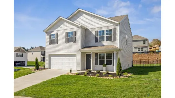 Charming suburban home with a lush green lawn, two-story design, and inviting front porch, set in a peaceful neighborhood.