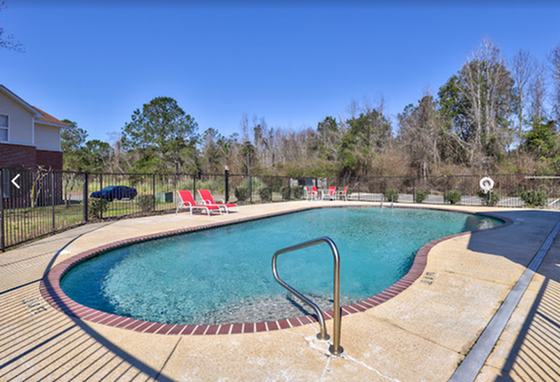 Inviting outdoor swimming pool with sun loungers, perfect for relaxation and leisure in a serene natural setting.