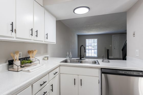 Modern kitchen design with sleek white cabinets, stainless steel appliances, and elegant black fixtures.