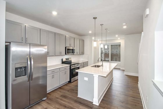 Sleek modern kitchen with stainless steel appliances, gray cabinets, and a spacious island.