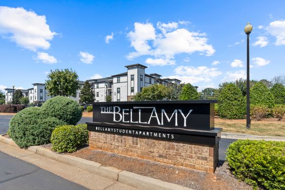 A two-story apartment complex with a welcome sign outside. | Bellamy Milledgeville