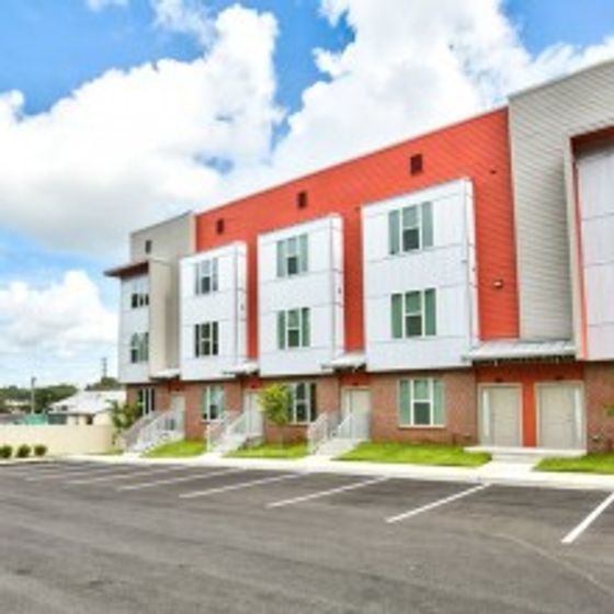 Arive Housing 850, LP, exterior, white, gray and orange building, three levels, parking, grass,