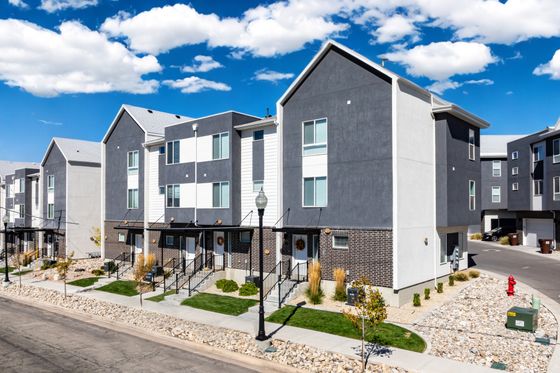 Charming modern townhouse complex with stylish architecture under a bright blue sky.