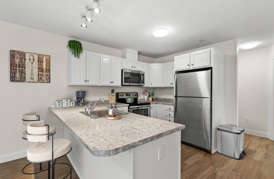 Contemporary kitchen featuring sleek stainless steel appliances, elegant granite countertops, and cozy bar seating.