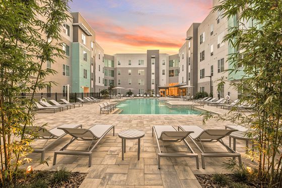 The Tiffany at Maitland West Apartments, exterior, sparkling blue pool, lounge chairs, apartment pool deck courtyard