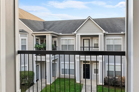 Charming view of elegant apartment exterior with lush green courtyard at Cason Estates Apartments