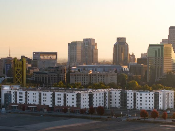 A stunning cityscape with modern at 805 Riverfront Apartments apartment buildings and towering skyscrapers at sunset.