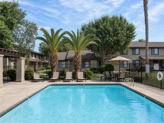 Inviting apartment community pool surrounded by lush landscaping and comfortable lounge chairs, perfect for relaxation and enjoyment at Camelot Apartments in Yuma, AZ.