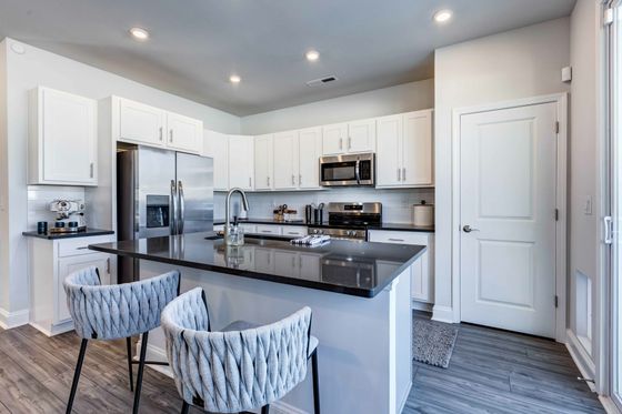 stainless steel appliances, custom white cabinetry, and kitchen islands
