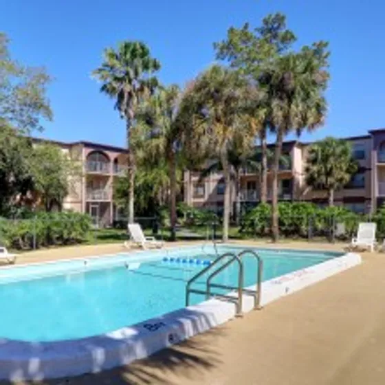 Lenox Apartments Inc, exterior, sparkling blue swimming pool, palm trees, buildings, balconies