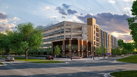 Modern apartment complex with sleek architecture, vibrant street view, and ample parking, nestled in lush greenery at sunset.