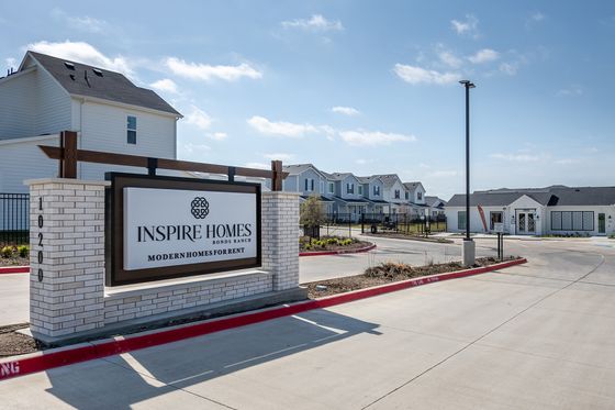 Sunny exterior view of Inspire Homes, showcasing modern rental homes with a welcoming entrance and contemporary design.