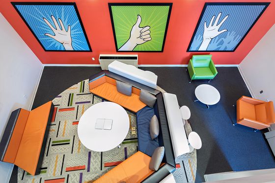 Resident lounge with bright furniture and art at Campus West apartments for rent in Syracuse, NY near Syracuse University.