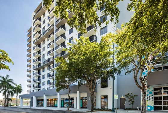 Intown, exterior, tall white building, balconies, trees, street,