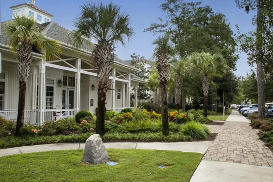 Charming residential building with lush landscaping and palm trees, offering a serene and inviting atmosphere.