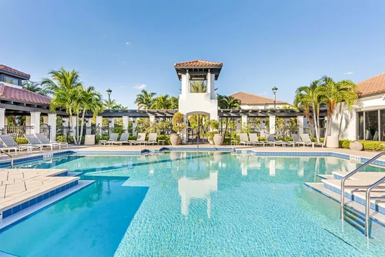 Inviting outdoor pool area with lounge chairs and tropical palm trees, perfect for relaxation and leisure.