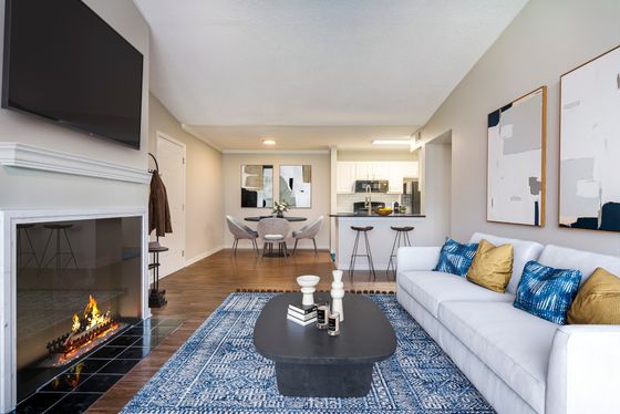 Chic open-concept living space with modern decor, featuring a cozy fireplace, elegant kitchen, and stylish dining area.