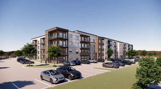 Modern apartment complex with stylish architecture, abundant greenery, and spacious parking, set against a clear blue sky.