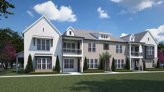 Charming townhouse with elegant white siding and brick accents, featuring a cozy balcony, lush green lawn, and picturesque landscaping.