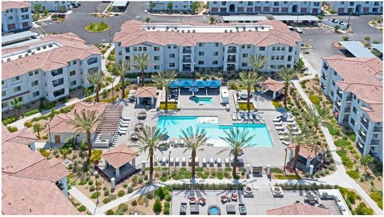Aerial view of a modern apartment complex featuring luxurious swimming pools, stylish cabanas, and lush landscaping.