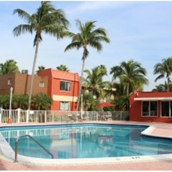 Cherry Grove Village, exterior, sparkling blue pool, palm trees, clubhouse