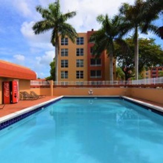 International Club Apartments, exterior, sparkling blue swimming pool, palm trees