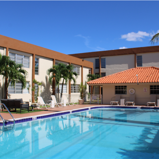 Las Brisas Gardens Apartments, exterior, sparkling blue pool, lounge chairs